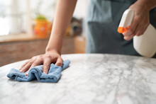 Asian Woman Cleaning The Table Surface With Towel And Spray Detergent