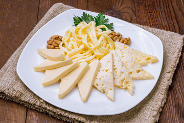 Wall Mural - a plate of different Caucasian cheeses on wooden table