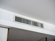 Air Conditioning Wall Mounted Ventilation System On Ceiling In The White Hotel Room. Hotel Room Air Ventilation Grill On The Wall.