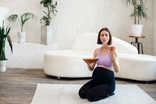 Beautiful Pregnant Woman Sitting In Yoga Position In Spa Room, Holding Coco Candle