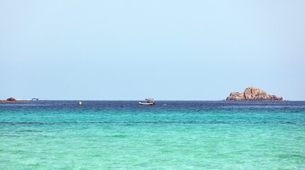 deserted rock island on the lovely sea without people idyllic landscape with a dinghy and people bathing