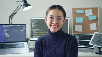 Wall Mural - Portrait young Asian woman developer programmer, software engineer, IT support, wearing glasses look at camera and smile enjoy working at home.