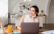 © NaMong Productions - Beautiful young asian woman working on laptop computer while sitting at the kitchen room background.