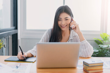 Fototapete - Asian woman Graphic Design Studio Drawing Ux Ui Website using mobile smart phone contact us support services Technology Creative Occupation freelance with tablet computer agency working happy smiling