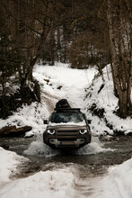 Beautiful View Of The Off-road Car Driving Through The River In The Winter Snowy Forest