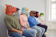 © Studio Romantic - Diverse people in rubber animal head masks sit on chairs in line wait for recruitment talk or interview in office. Unknown men and women in headmask in queue. Fun and joking.