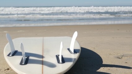 Wall Mural - Surfboard for surfing lying on beach sand, California coast, USA. Ocean waves and white surf board or paddleboard. Longboard or sup for watersport recreation by sea water. Seamless looped cinemagraph.