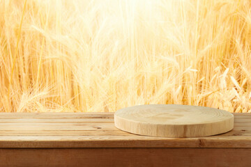 Wall Mural - Empty wooden log on table over wheat blurred background. Shavuot holiday mock up for design and product display