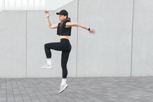 Fit Sportswoman Jumping In City