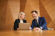 © baranq - Smiling businesswoman and businessman meeting in conference room at modern office