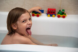 Fototapeta  - Sześcioletni chłopiec bawiący się w kąpieli plastikowymi samochodami