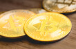 © Rmcarvalhobsb - Bitcoin, criptomoeda. Moedas douradas representando o Bitcoin em superfície de madeira em fotografia com vista de perto.
