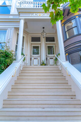 Perron staircase of a stylish residential building with two front doors and transom windows