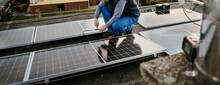 Worker Installing New Solar Panels On Roof Of Family House. Alternative Energy. Cover Photo