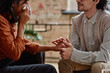 © Mediaphotos - Horizontal shot of young man working as professional psychologist comforting woman crying during session holding her hand