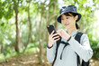 森林でスマートフォンを使う女性