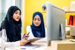 © Art_Photo - Muslim two asian woman freelancer sme business online shopping working and checklist order with cardboard box on table at home - Business online shipping and delivery concept
