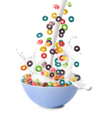 Pouring milk in bowl of colorful cereal rings on white background