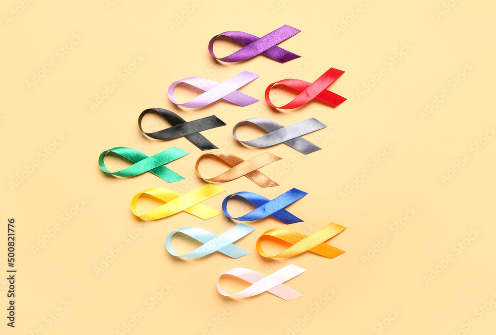 Colorful awareness ribbons on beige background. World Cancer Day concept