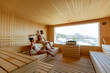 © BGStock72 - Young couple relaxing in the sauna and watching winter forest through the window