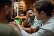© Westend61 - Three frustrated male soccer fans having beer and watching a match on smartphone in a pub