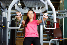 Woman Doing Workout With Exercise Machine In Gym