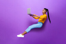 Astonished Black Woman Levitating While Working On Laptop