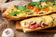 Pizza cooked on a baguette. Sandwich pizza with shrimps, cheese and sausages, close-up, selective focus.