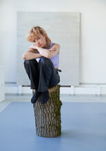 Young Woman Sitting On Log
