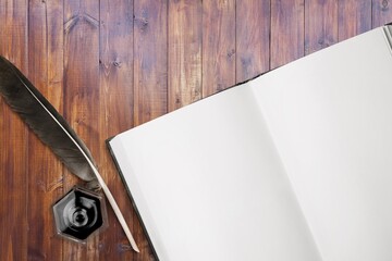 Wall Mural - open old antique book with quill pen and bottle of ink.