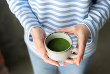 Hands Of Woman Holding Cup Of Green Tea