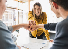 Happy Business Team Touching Fists In Office