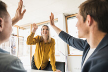 Happy Business Team High Fiving In Office