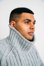 Young Man Wearing Gray Sweater Against White Background