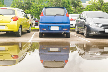 Wall Mural - Wet parking lot with car parking in a row. CarsWet parking lot with car parking in a row. Cars park in open parking lot after rain.