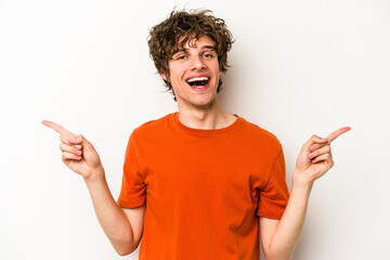 Young caucasian man isolated on white background pointing to different copy spaces, choosing one of them, showing with finger.