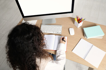 Wall Mural - African American woman studying at table indoors, above view. Distance learning