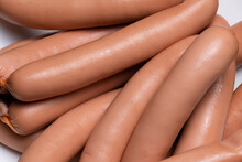 Close-up Of Sausages For Hot Dogs Made Of Raw Chicken Meat On A Plate On A Dark Background.