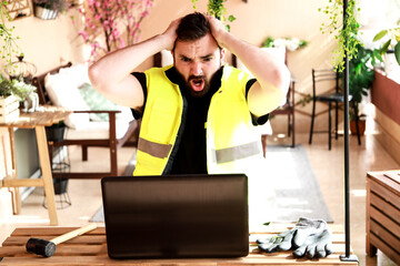 Wall Mural - 
Worker in his work area with a computer, gloves and a mallet hammer