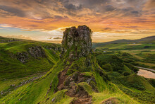 Powerful Sunset On The Isle Of Skye In Summer With The Rock Castle Ewen. Landscape In Scotland In The Evening With Clouds In The Sky. Path On The Cliff Edge. Road With A Small Lake