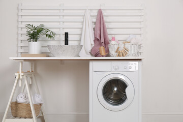 Canvas Print - Laundry room interior with modern washing machine and stylish vessel sink on white wooden countertop