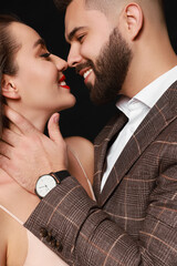 Wall Mural - Handsome bearded man with sexy lady on black background, closeup