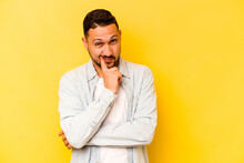 Young Hispanic Man Isolated On Yellow Background Contemplating, Planning A Strategy, Thinking About The Way Of A Business.