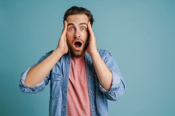 Young man holding his head while expressing surprise