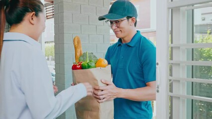 Wall Mural - Food Delivery concept. Asian delivery man hand giving bag of food, fruit, vegetable delivery to costomer grocery delivery service.