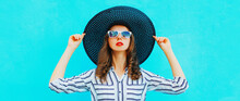 Portrait Of Beautiful Woman Model Wearing Black Round Summer Hat, White Striped Shirt On Blue Background