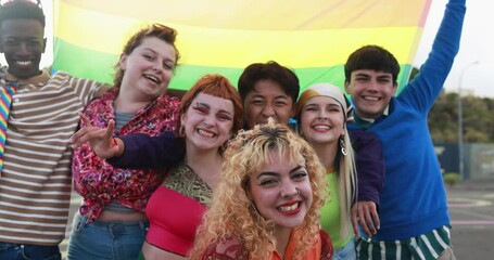 Wall Mural - Young diverse people having fun holding LGBT rainbow flag outdoor