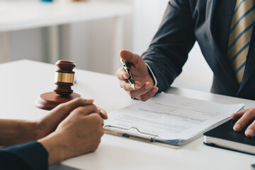 Business woman and lawyers discussing contract papers with brass scale on wooden desk in office. Law, legal services, advice, Justice concept.