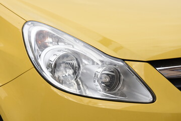 Wall Mural - 
Can Stock Photo
Bright shiny headlight. Bright shiny car headlight close-up. new clean led car light