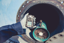 Worker Hand Holding Gas Detector Inspection Safety Gas Testing At Front Manhole Stainless Tank